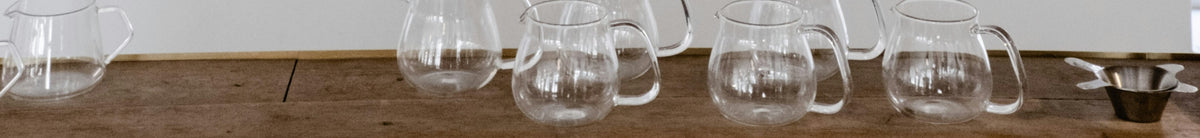 White wooden shelf styled with bottles and bowls